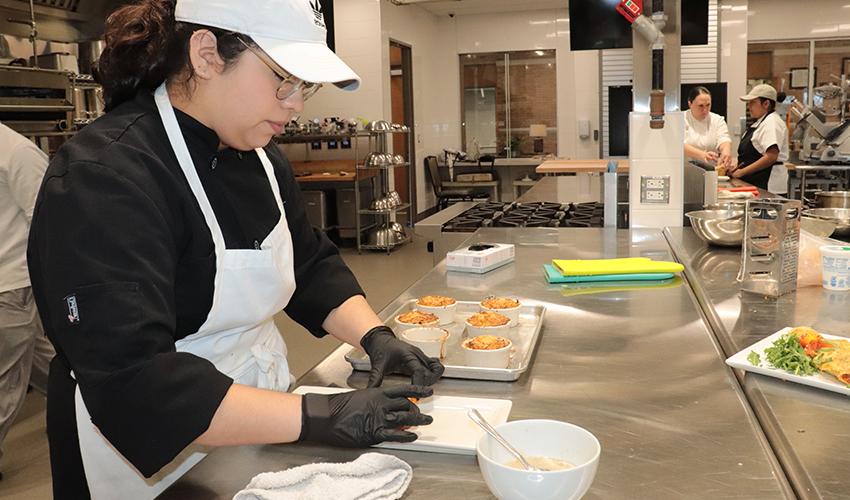 Culinary Arts student spends time plating her culinary dish.