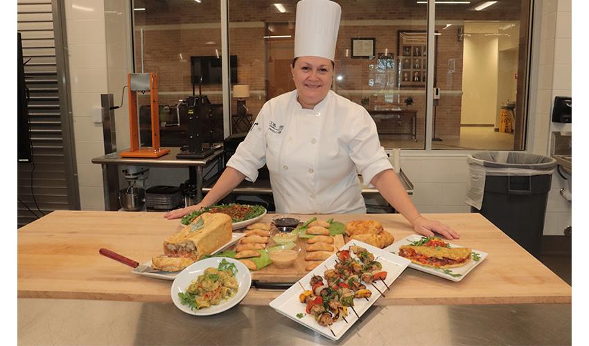 Picture of the Chef Laura standing behind the students dishes.